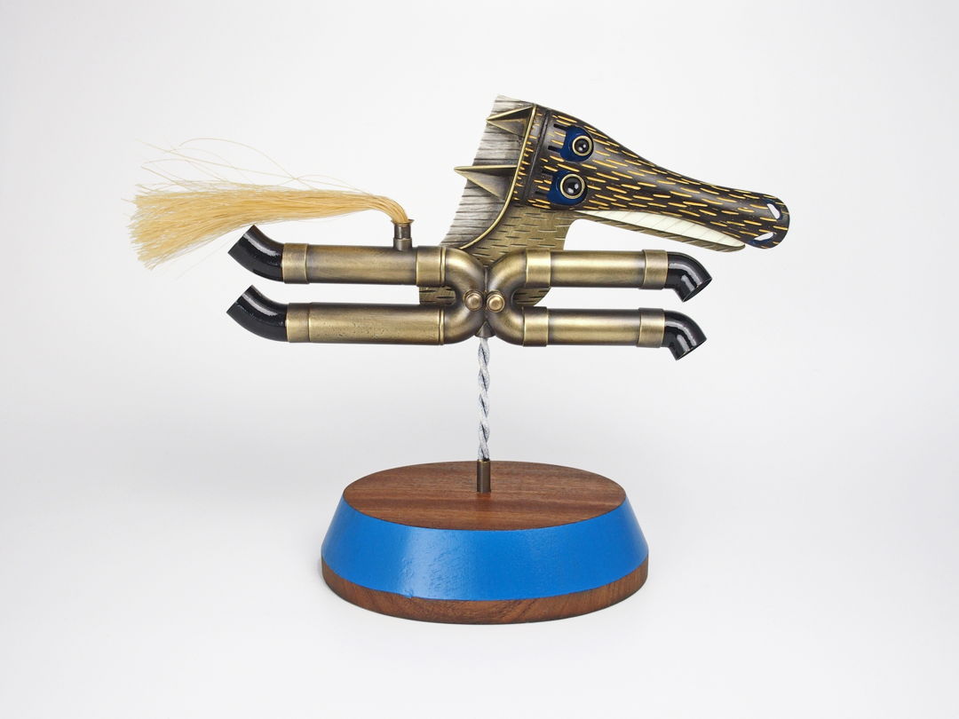 Freestanding object with removable brooch/necklace. Necklace: 19" stainless steel and sterling silver. Brooch/Pendant - 4.25 x 4.5 x 3.25". Horse spins on stand.