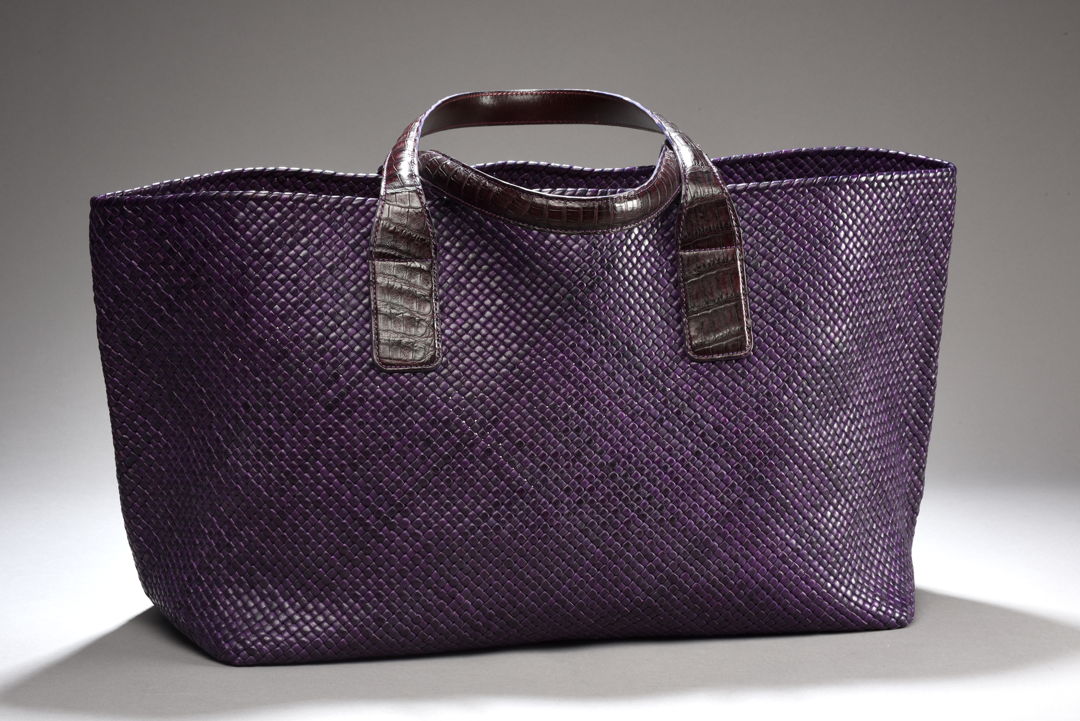 This purple tote was handcrafted from natural veg-tanned goatskin leather strips that were individually hand-cut  edge-thinned  edge-dyed  and folded into 3/16-inch wide strips then woven the traditional way using basic weaving pattern. Provided with natural veg-tanned alligator leather handles.