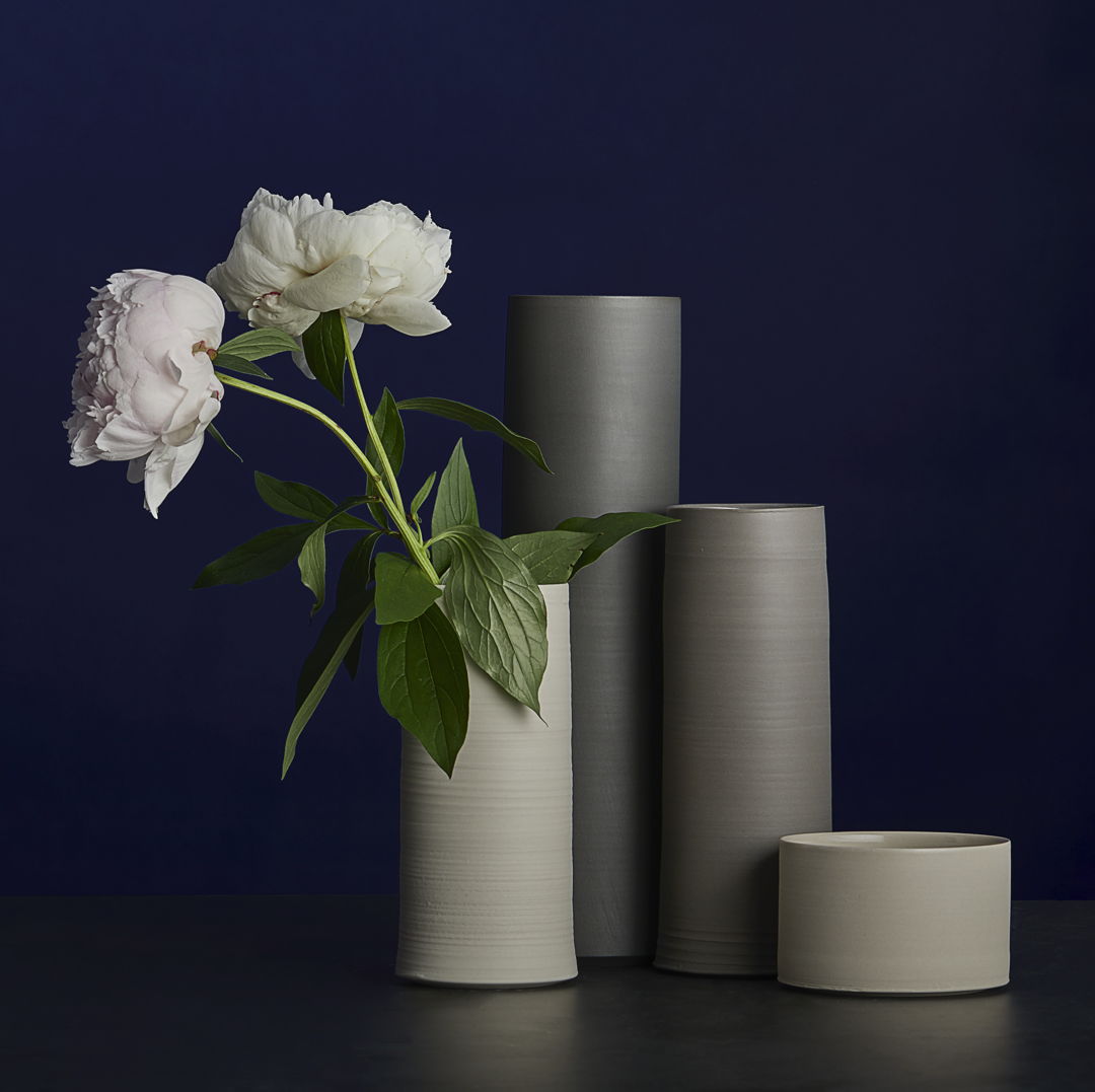 cluster of four simple cylindrical vases of varying heights and earthy hues