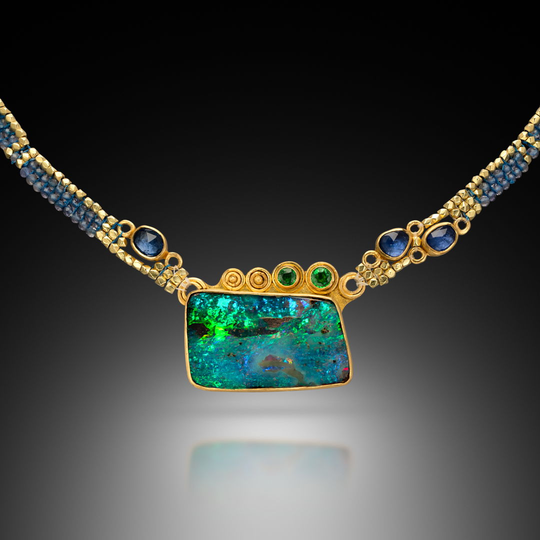 Hand-woven collar with tanzanite and 20k gold beads. Hand fabricated bezel with 22k gold  set with a colorful boulder opal from Australia  small faceted tsavorites  and blue rose cut sapphires