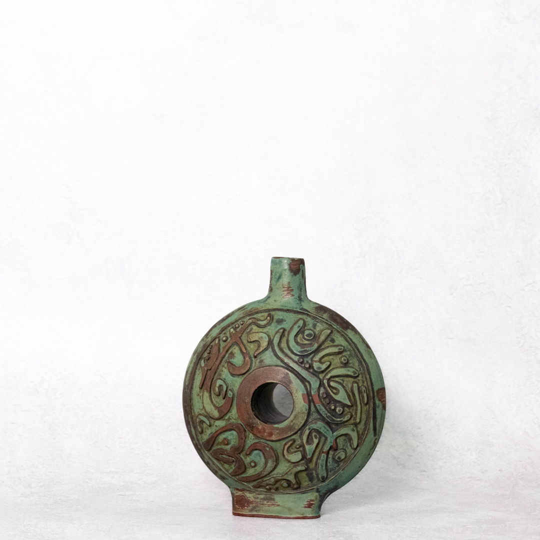 greena and brown vase with center hole and inscription