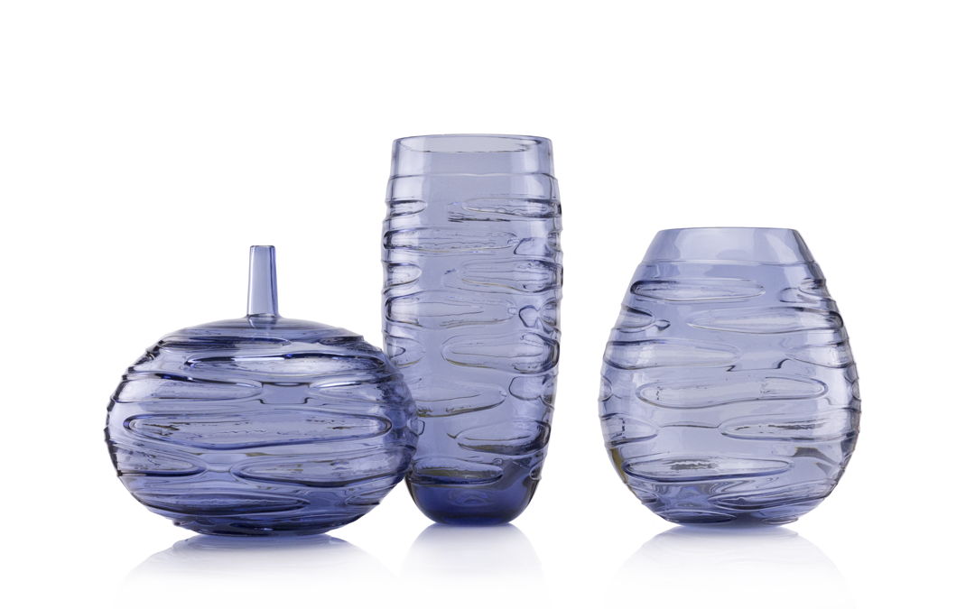 The INCISION SERIES of bottles + vases are created using a “stuffed cup” technique. A cup is blown  cooled  cut  brought back up to temperature and reformed into each shape we offer. Offered in translucent monochromatic color ways to emphasize the unique torn texture.