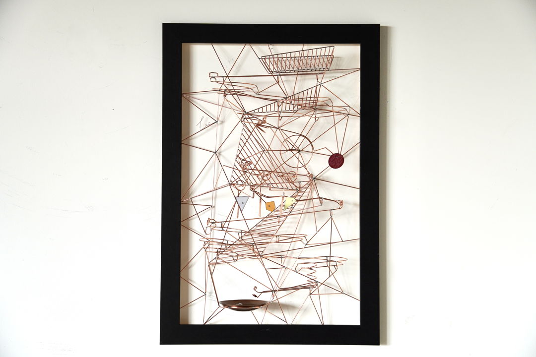 Wall-mounted copper wire kinetic sculpture in wooden frame. Marbles can be taken from the copper bowl and dropped into the top of the sculpture to see them wind down the sculpture interacting with four moving elements.