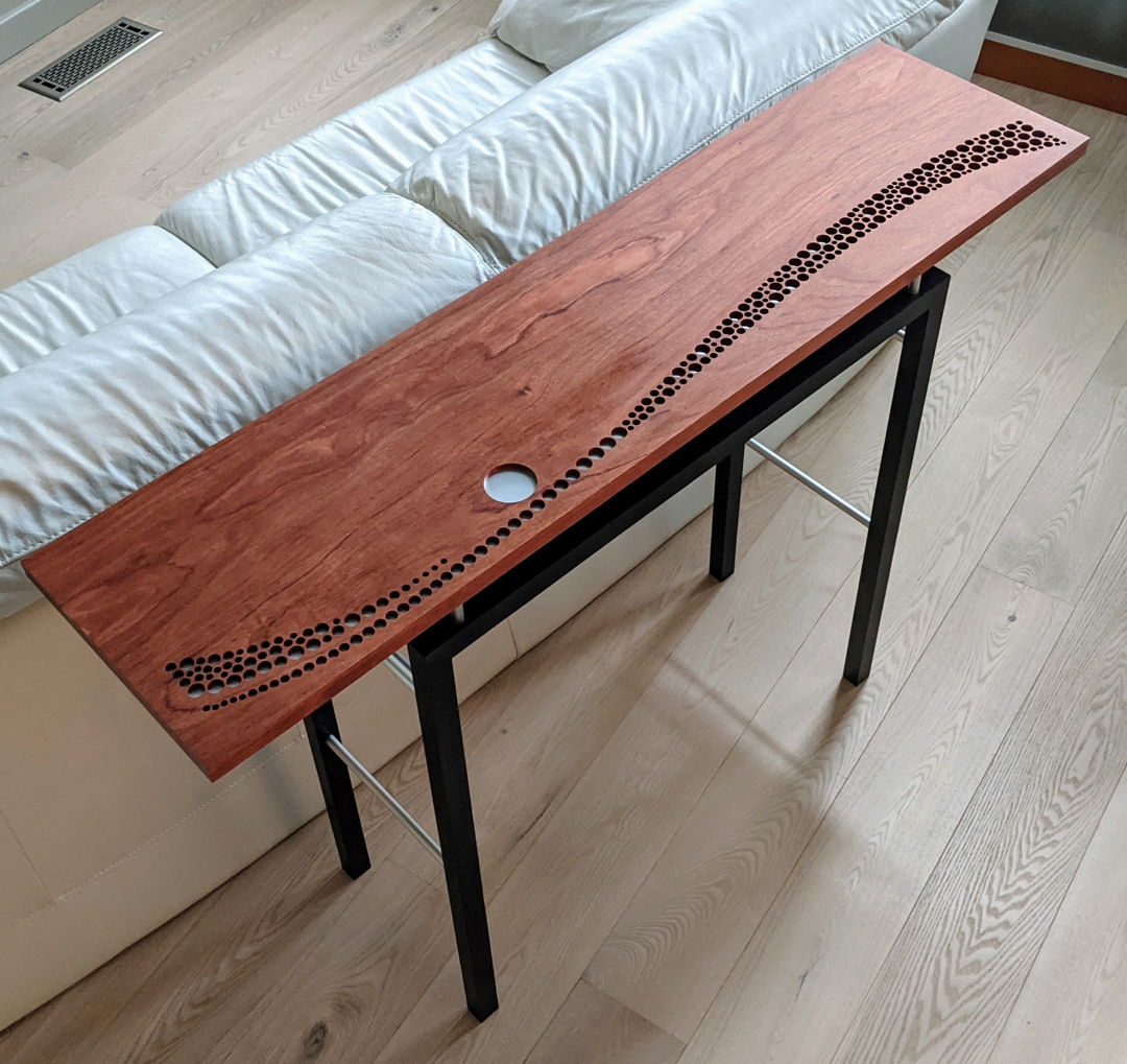 A three-dimensional landscape shimmering in the light of a full moon is created from circles drilled into the bubinga table top and underlaid with aluminum. The top floats above a base constructed from ebonized ash and anodized aluminum tubes. Limited edition of 12