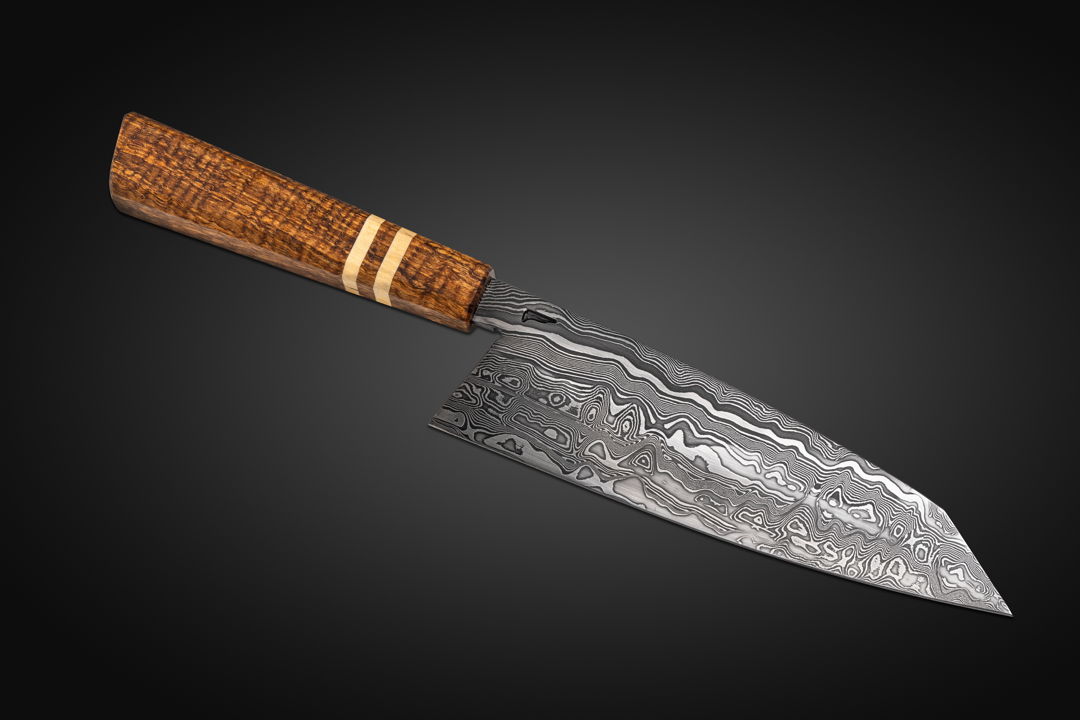 My seven inch chef's knife  the Damascus I diffusion bonded from 26C3 and 15N20 steels  and I made the handle from Curly Javanese Mango  with American Holly Accents.