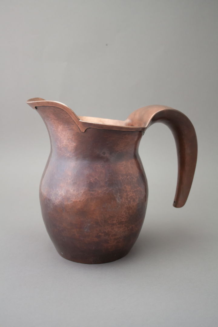 Hand raised copper pitcher with hollow handle and cut-card decoration