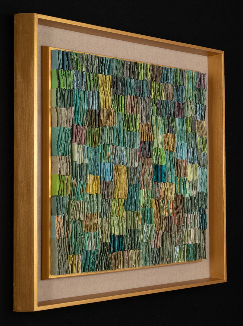 Double-sided handmade abaca/linen paper  folded  cut  attached to backing. Shown in gold painted wood shadow box