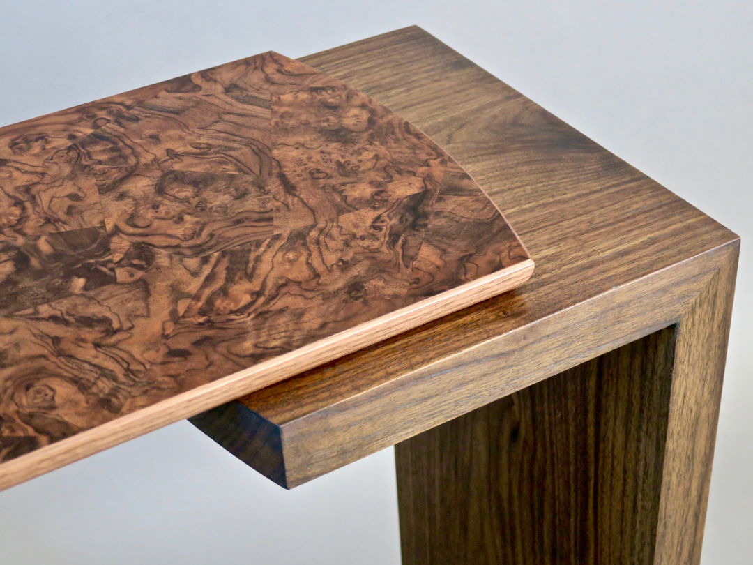 Detail- Havana series console table. The base is made of walnut with a top featuring a walnut burl veneer in an Asian cracked ice pattern.