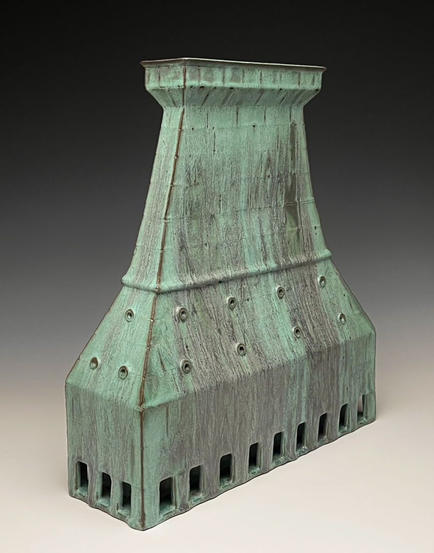 hollow, tower-like clay form with weathered bronze look.