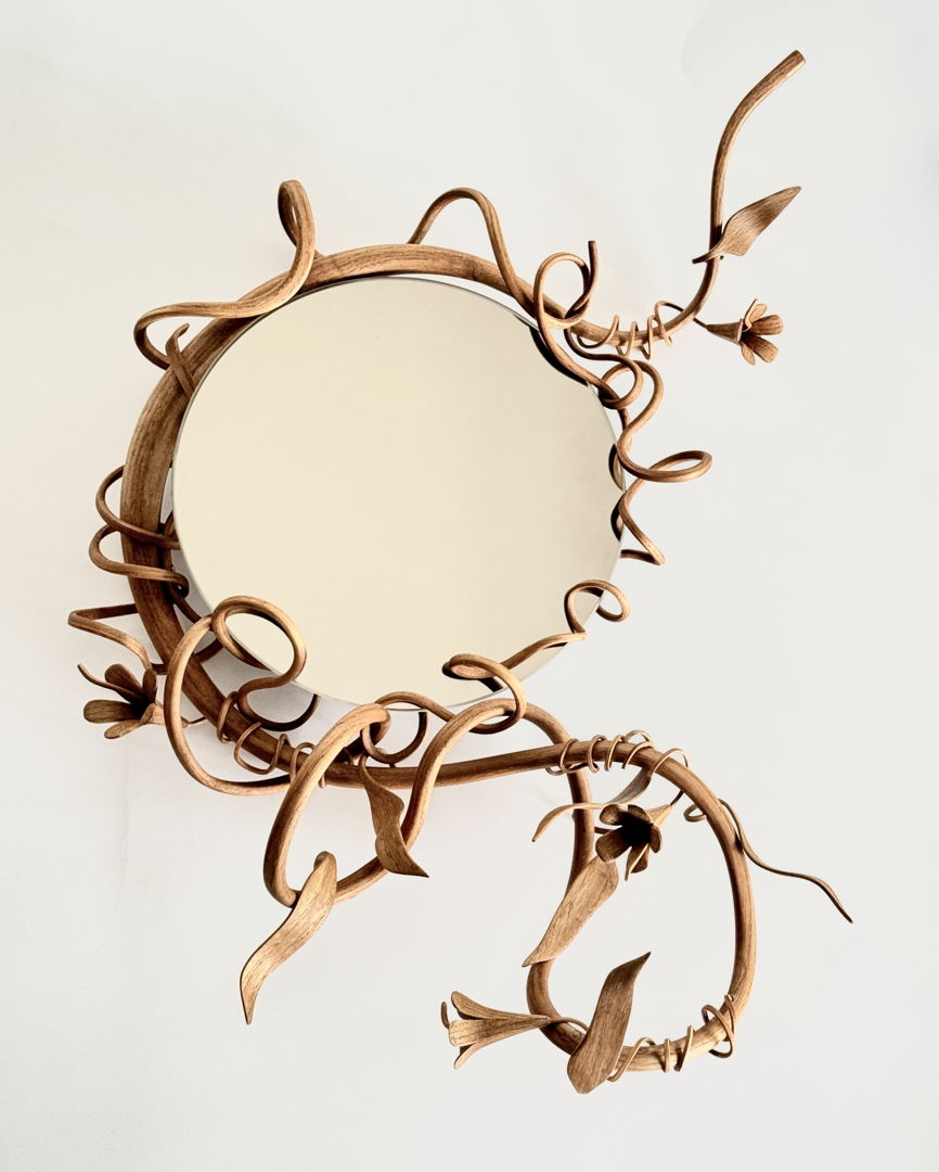 Smokey Mirror framed by a steam bent sassafras vine that undulates with leaves and buds.