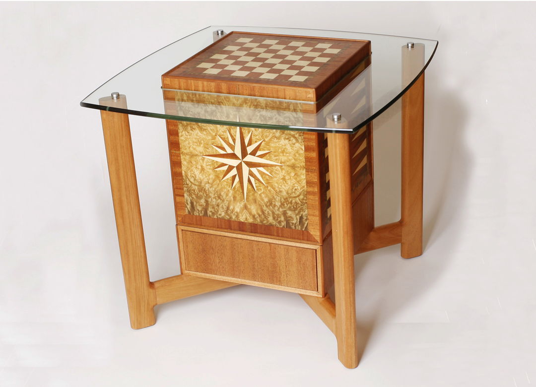 The innovative design of this piece allows it to be used as an end table  but it functions as a game table. Lift and turn the cube to play chess  checkers  backgammon  or Scrabble. Game pieces stow neatly in the drawer beneath. (mahogany  holly  laurel burl  glass)