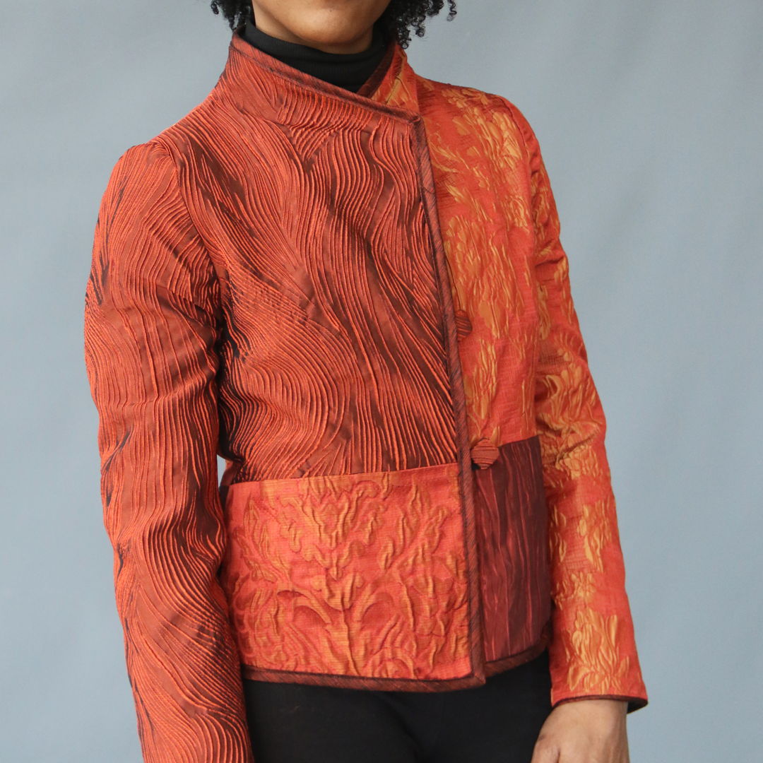 Pieced jacket of iridescent  orange  textured silk with coordinating bias  collar and matching handmade buttons.