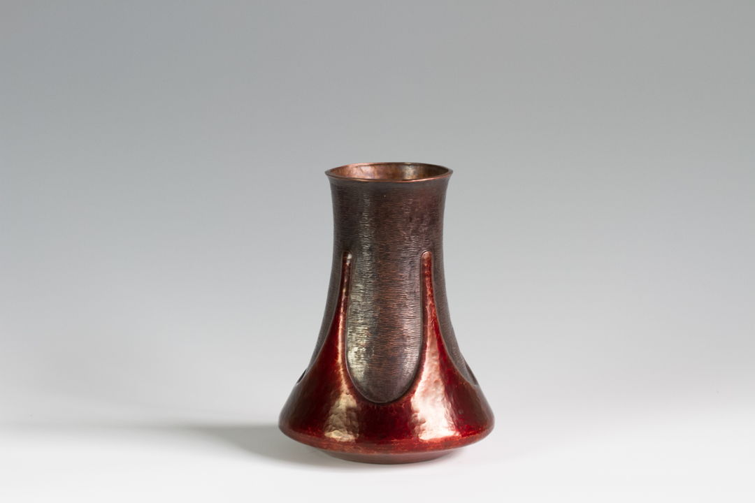 This vase is hand raised from a single sheet of copper. The form is then chased and textured before a vivid red patina is applied.