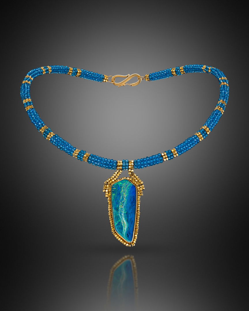 Collar  hand-woven with blue topaz and 18k gold beads. Pendant  hand fabricated 18k gold bezel  surrounded by woven 18k beads  and set with an Australian opal.