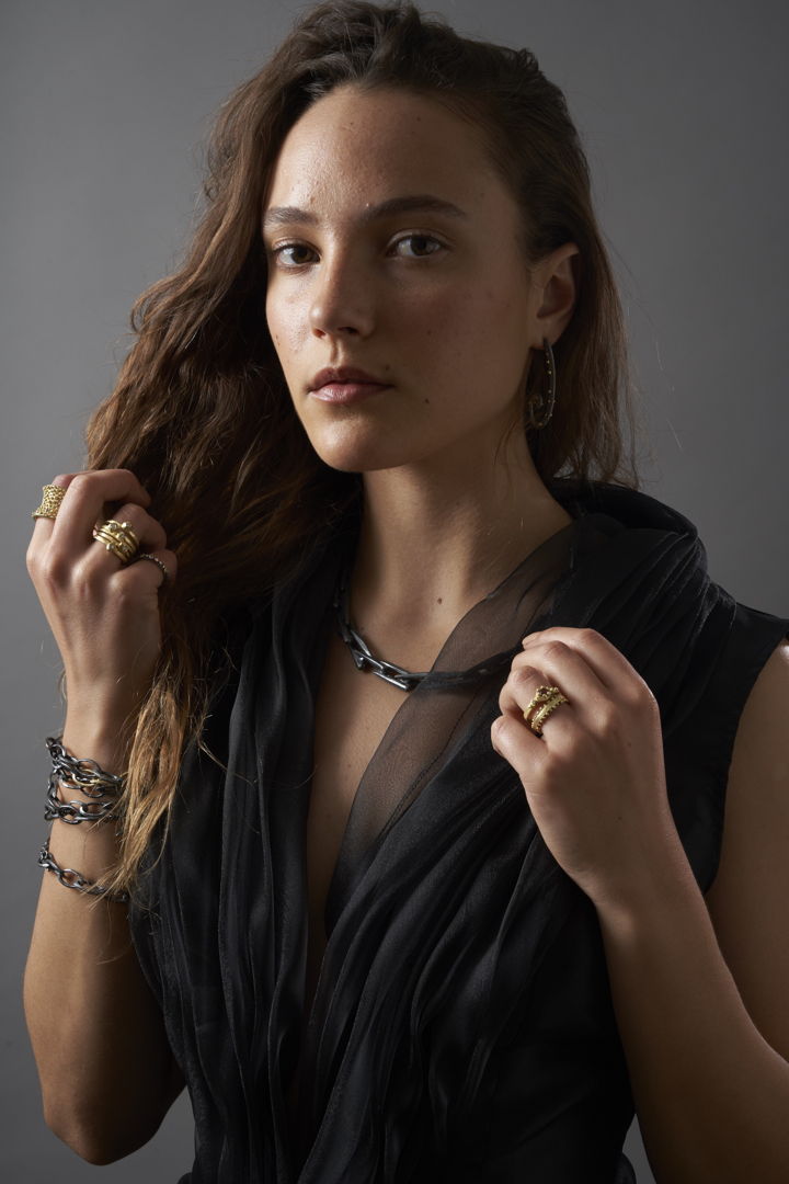 model wearing sterling silver and 18k gold assortment of rings  earrings  bracelet  and necklace.