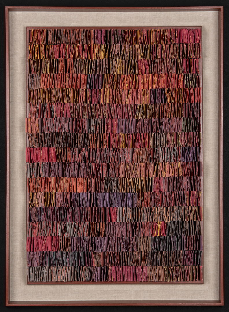 Double-sided handmade abaca/linen paper  pigmented in tones of red and brick. Folded and cut  assembled. Shown in red painted wood shadow box