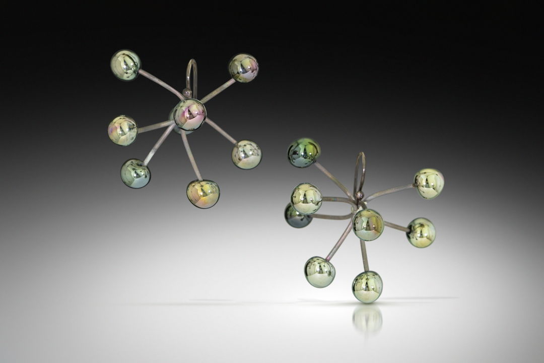 Earrings made from high-silver metallic glass melted directly onto little titanium 'branches'. The branches can be arranged to span out wide in a sputnik shape or cluster more closely together for a different effect.