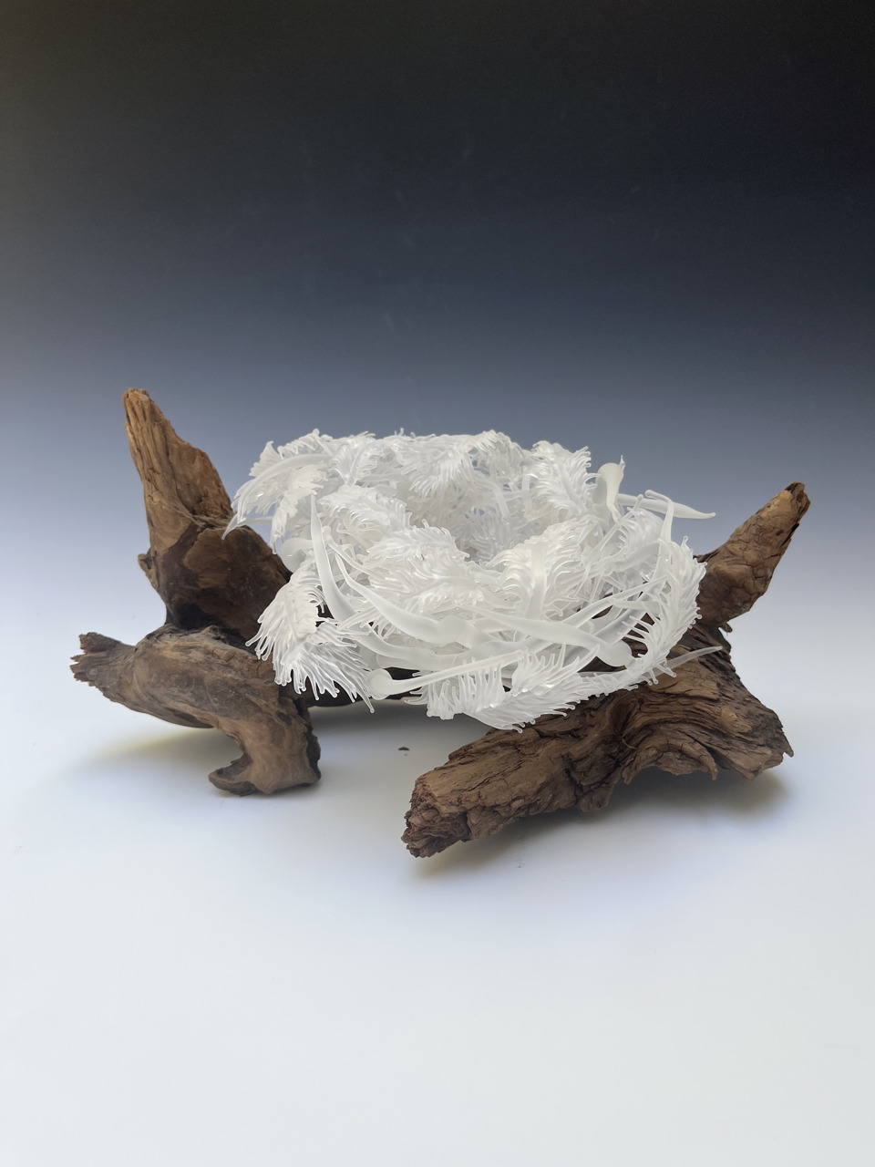 glass sculpture of nest on branches