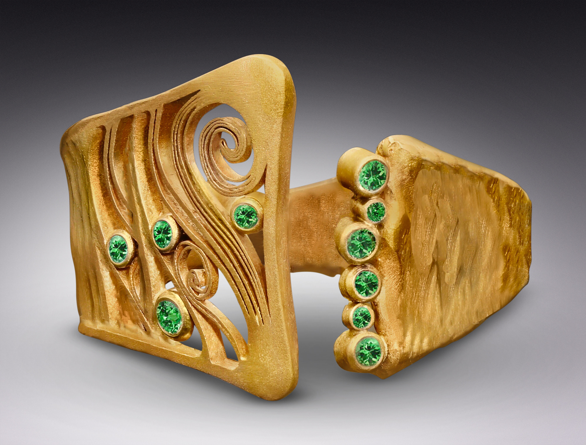 gold cuff with small green stones