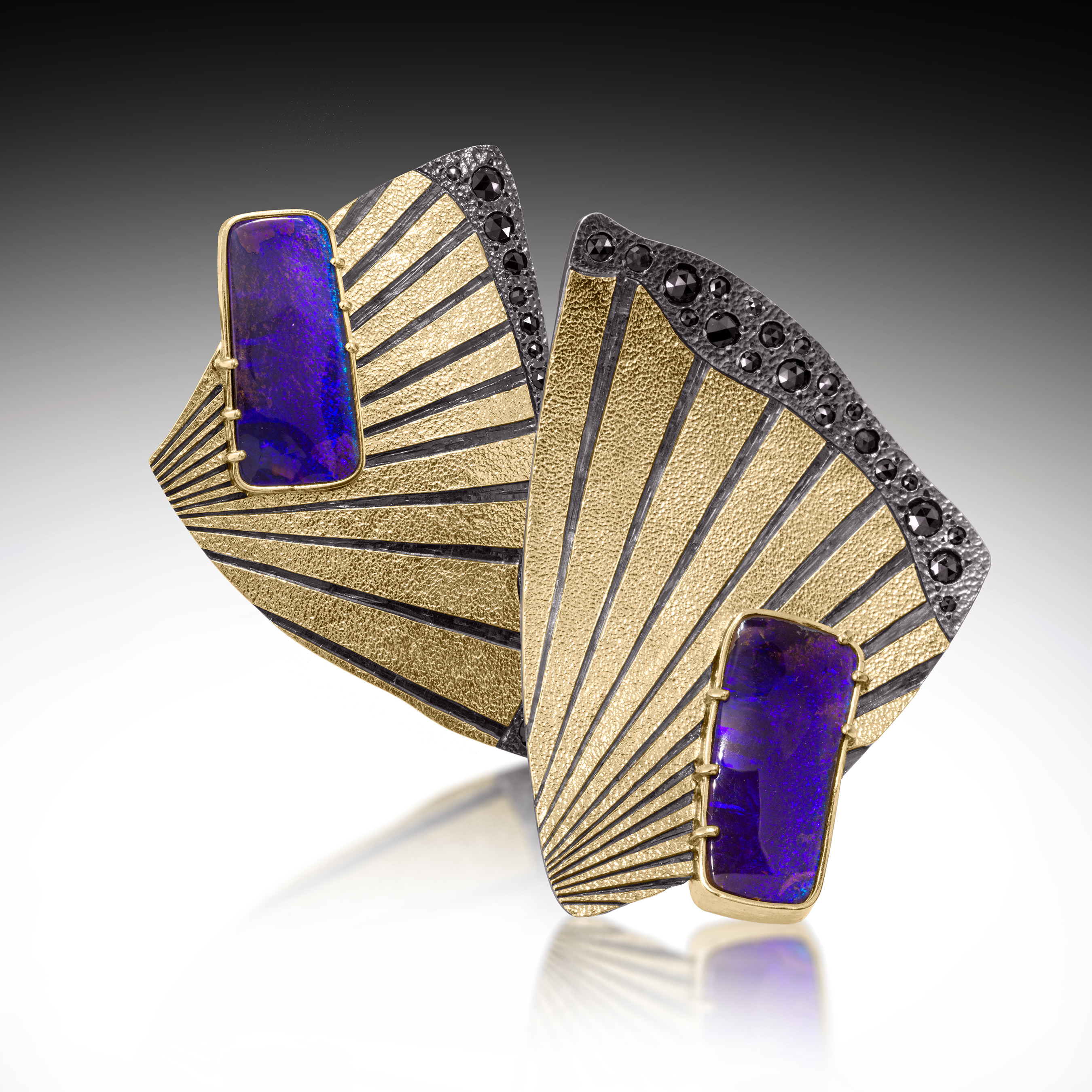 two metal jewelry pieces with blue stones