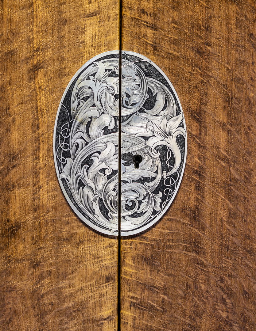 The nickel silver escutcheon plate is engraved with an acanthus and lily pattern.
