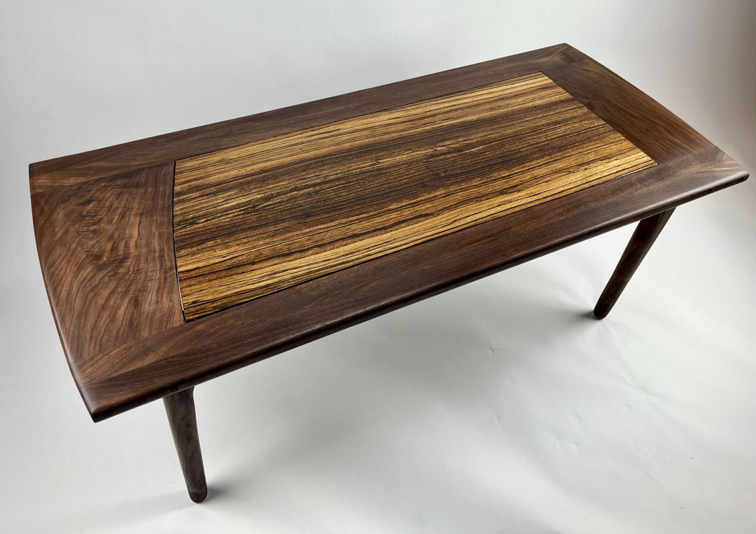 Sculpted coffee table in walnut and zebrawood