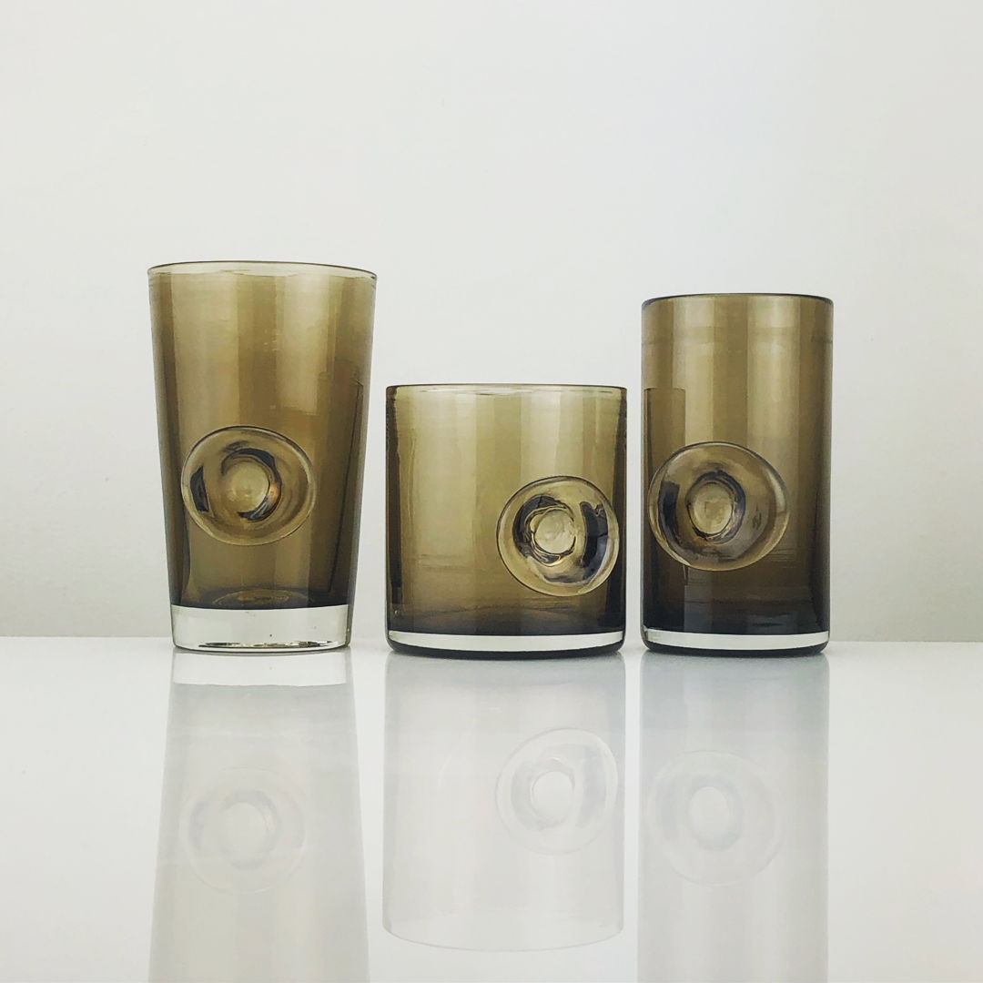 Each glass is finished by adding a bit of molten glass to create an optical lens effect  magnifying the inside. Additionally it functions as a thumbprint helping you hold the glass. This process also makes each one truly unique  adding a handmade touch to a well made and consistently crafted object.