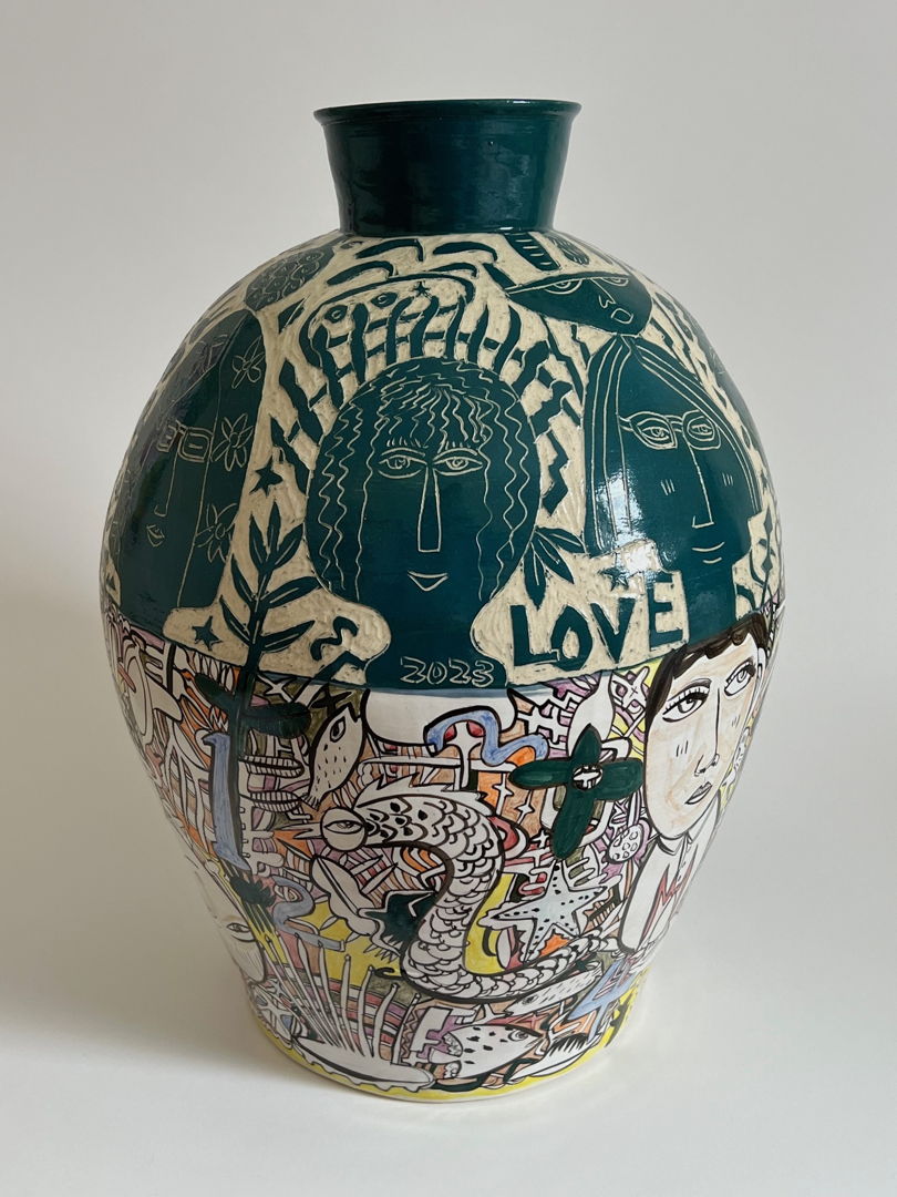 cermic vase, the top half is decorated with black and white sgraffito, the bottom half decorated in multicolored glaze illustrations.