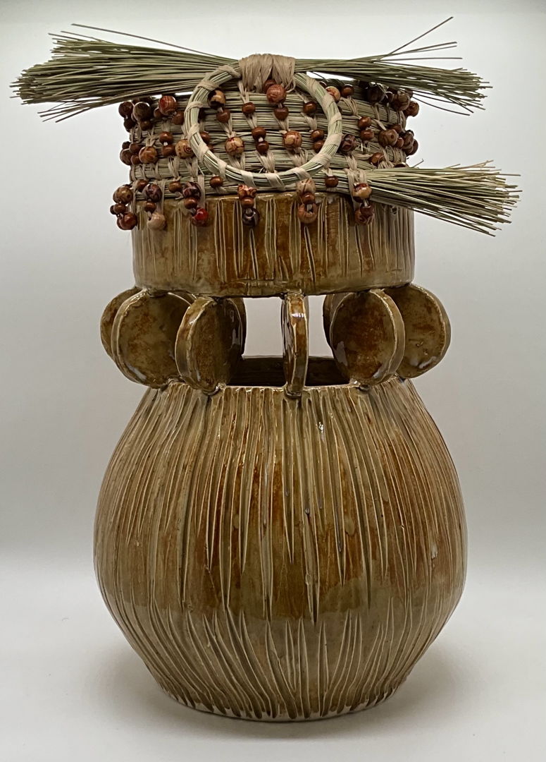 Wheel thrown vessel thrown in two parts  whereby connecting both parts with ceramic circles with precision. South Carolina coastal sweetgrass attached wooden beads to highlight both art forms
