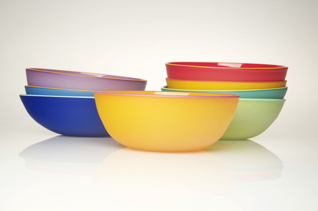 Blown glass vessels made from opaque colored glass with contrasting colored glass lip wraps. Etched on the outside.