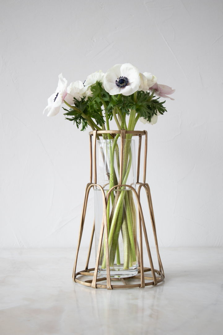This basket vase features a woven design made from forged brass. It can be used to elevate a bouquet of fresh flowers  or simply as a one-of-a-kind artistic piece. A glass cylinder is also included.