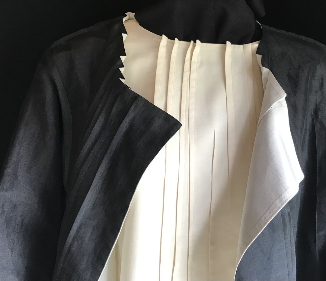 Silk/wool reversible jacket shown over matching top. Linear surface design created by detailed folding and stitching.