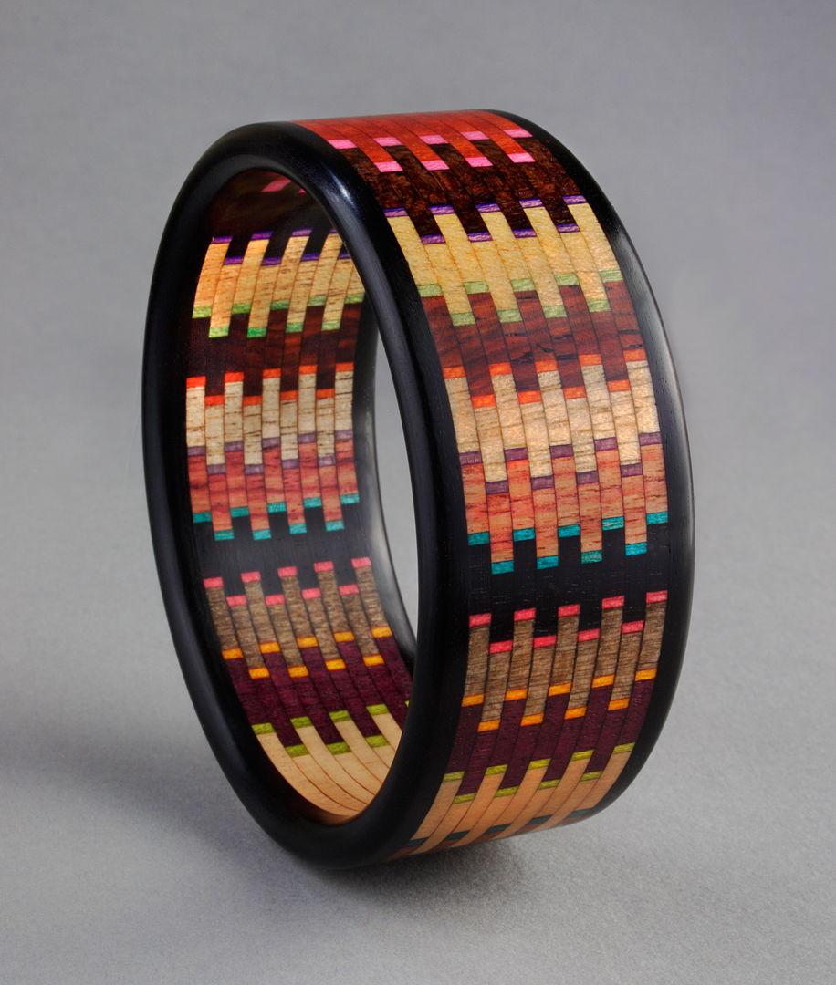 Linear Mosaic Bracelet made with the natural colors and grains of 12 different specie of wood and artist hand dyed veneers. Ebony edges  Brillant series  comprised of 400 individual pieces of wood.