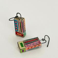 The detailed and unique patterns on these earrings remind the artist of tapestries  thus their name. Tapestry Earrings are hollow 3-dimensional rectangular-shaped earrings with hammered annealed steel curved dangles. Mat board is used to create the rectangular structures  with layers of various papers “painted” on with brush &amp;amp; glue for both base colors and patterns. The earrings are sealed for use.