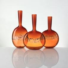 These vessels are created with an optical band of copper foil that when reacted with the glass  turns a bubbly blueish tone. We also create these handblown bottles with silver foil in the same painterly application that turns a beautiful goldish/blue tone. 