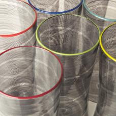 Clear blown glass vessels with black rods of clored glass or canes fused into the surface  blown and twisted. Each piece is finished with a colored glass lip.