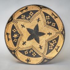 A wood basket tray made on a wood lathe. Wood is then embellished with India Ink and a burning pen.