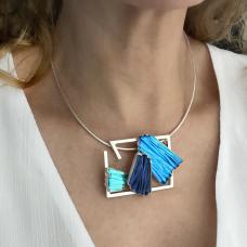 Model wearing metal necklace with glass pendant