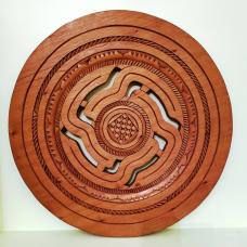 Wall art carved of tropical cedar: the circle of cutouts represent the passage of life and the carving tradition from one generation to another  