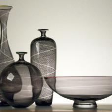 Blown Glass vessels made from clear glass with fused black canes or rods of black glass melted into the surface and twisted while blown. Each piece is finished with a red colored glass lip.