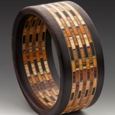 12 different hardwood specie of sustainably harvested wood and artist dyed Maple veneer. Mum Ebony edges from Laos  The wooden fabric design has 300 individual pieces of wood. 